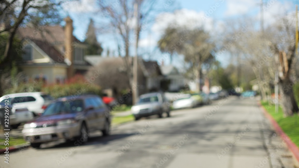 Defocused background of typical suburban/urban neighborhood with parked cars