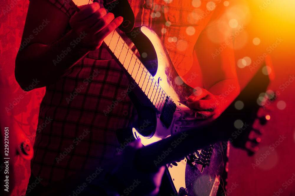 Fototapeta Life style image of close up young male guitarist hand, playing electric guitar