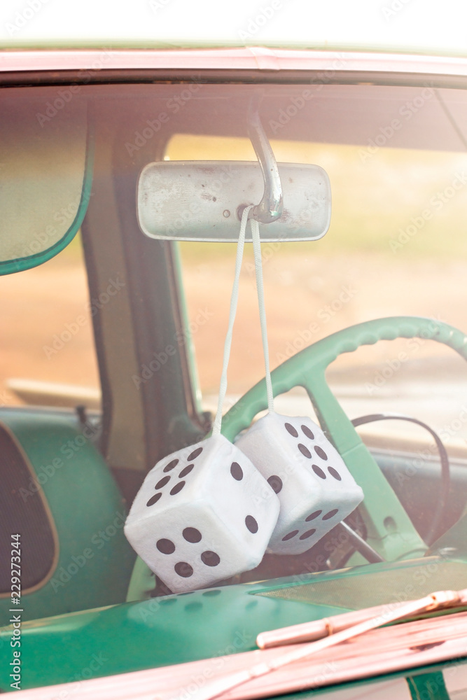 Fuzzy Dice Hanging from the Rearview Mirror of an Antique Car