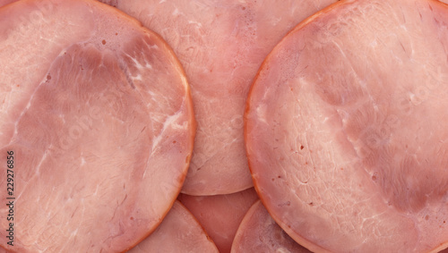 Close view of several round breakfast ham slices.