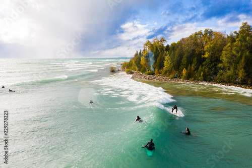 Photography Lake Huron, Ontario, Canada - October 17, 2018: Aerial view of a group of Great Lakes surfers catching waves during an autumn storm