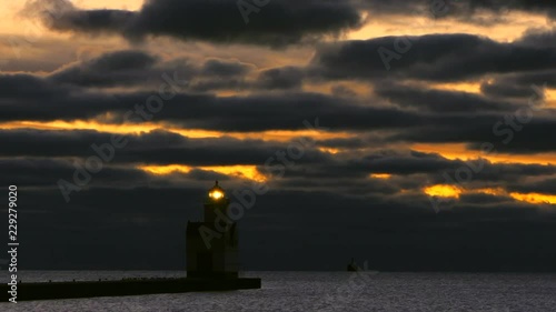 Dramatic dawn over harbor With majestic lighthouse, breathtaking time lapse sky and clouds. photo