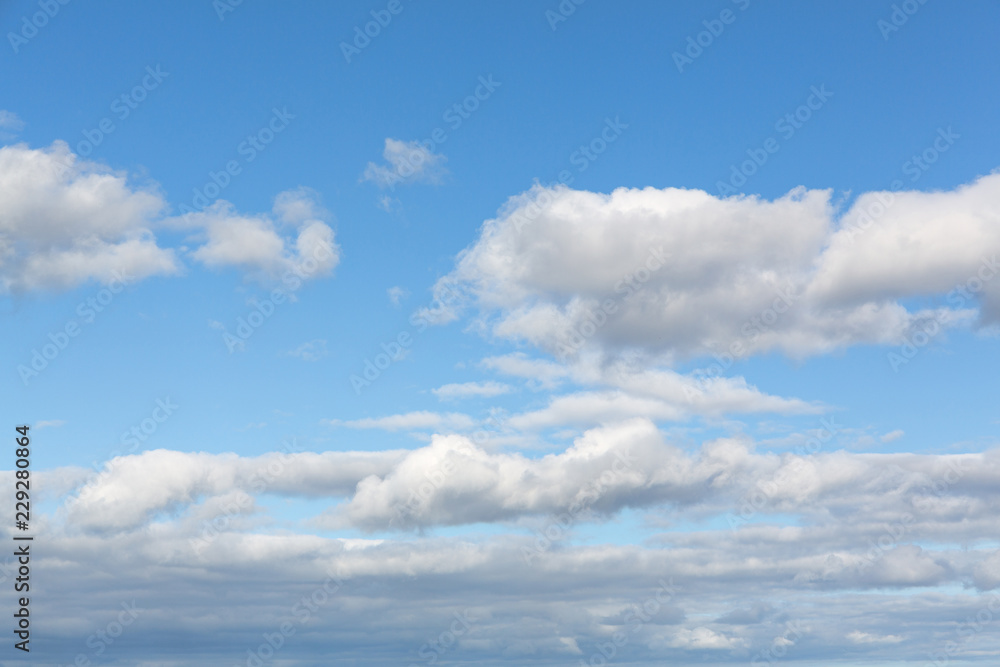 Blue sky with several scattered cumulus clouds.