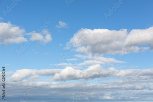 Blue sky with several scattered cumulus clouds.