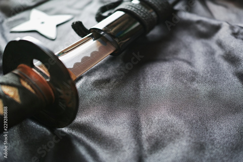 黒い布の上の抜きかけた日本刀と手裏剣 Stock Photo Adobe Stock