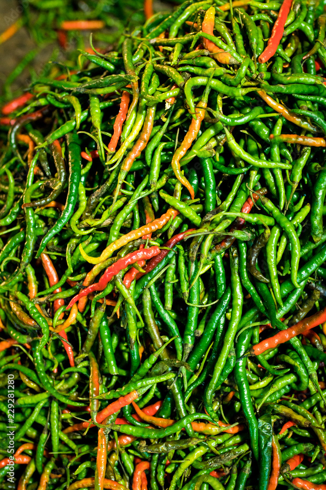 Close up of a pile of spicy red and green peppers at a night market Close up of a pile of spicy red and green peppers at a night market