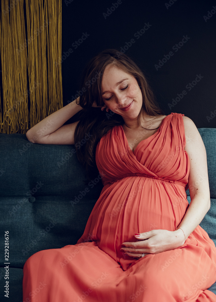 Pregnant woman sitting on a sofa Pregnant woman sitting on a sofa
