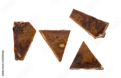 Pieces of an almond, cashew and date chocolate protein bar isolated on a white background.