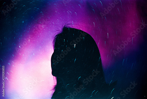 Silhouette of woman looking up at the night sky filled with stars photo