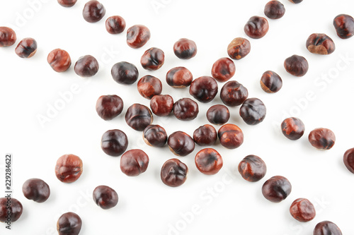 Many peeled chestnuts lie on white background