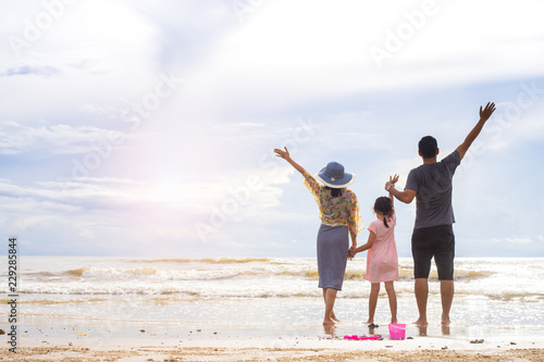 Happy family of three having fun on the beach