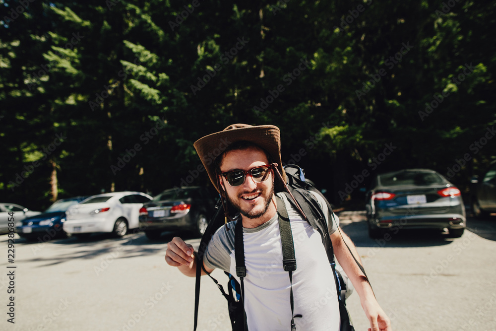 Man with cowboy hat and backpack in parking lot Man with cowboy hat and backpack in parking lot