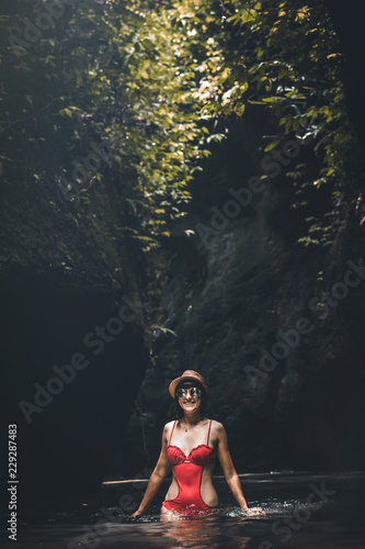 Fototapeta Naklejka Na Ścianę i Meble -  Young traveler woman in the jungle river. Rainforest of Bali island. Tourist adventure concept.