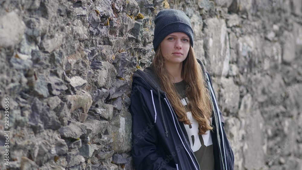 Girl leans against the wall and looks at the camera Girl leans against the wall and looks at the camera