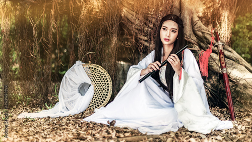 Beautiful Chinese woman with a traditional suit with a flute in her hands, Beautiful and belligerent face, Young woman with a samurai bushido