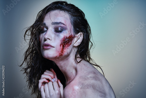 Beautiful girl with a wounded face in the blood