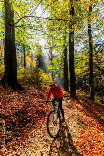 Mountain biking woman riding on bike in early spring mountains forest landscape. Woman cycling MTB enduro flow trail track. Outdoor sport activity.