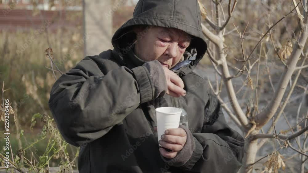 Portrait homeless woman vagabond in a temporary place is drinking vodka. Lifestyle people concept. Portrait homeless woman vagabond in a temporary place is drinking vodka. Lifestyle people concept.