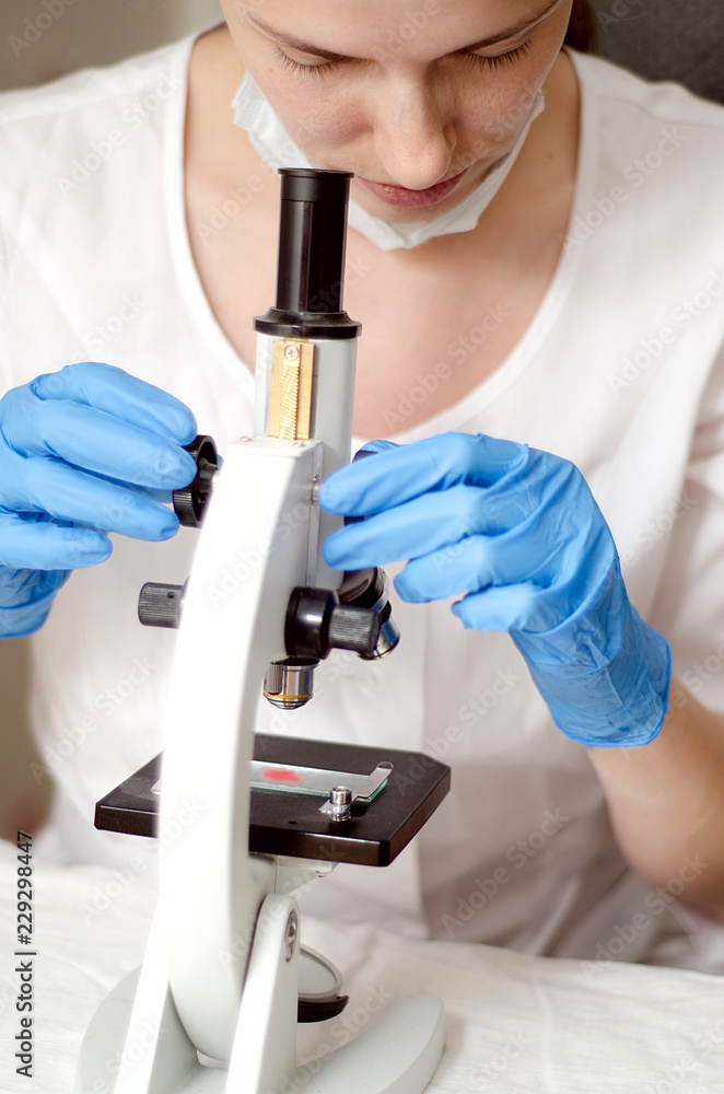 Doctor a pathologist examines under a microscope the tissue sample Doctor a pathologist examines under a microscope the tissue sample