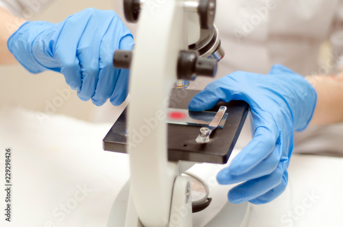 Doctor a pathologist examines under a microscope the tissue sample