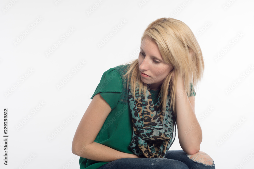 Pretty, young, blonde woman, sitting, hand in hair, looking away Pretty, young, blonde woman, sitting, hand in hair, looking away