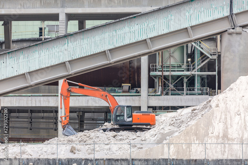 Excavator on a sand mound at an industrial site photo