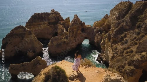 4k drone - Woman above Ponta da Piedade. Algarve region.  Lagos, Portugal.