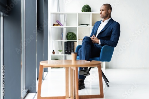 Handsome cheerful african american executive business man at the workspace office.