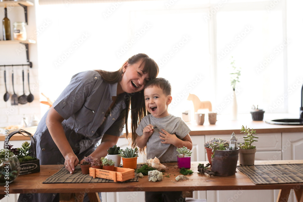 Mom and son cheerful emotional take care of plants Mom and son cheerful emotional take care of plants