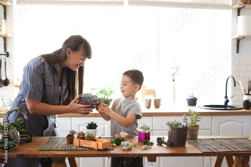 Mom and son cheerful emotional take care of plants