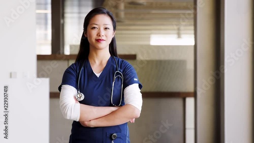 Young Asian female doctor wearing scrubs photo