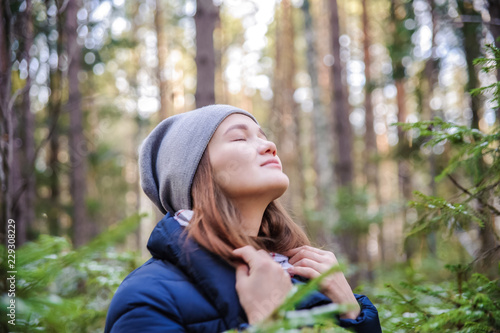 girl enjoys the smell of autumn forest photo