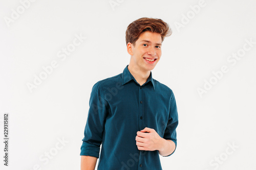 Charming young man coquettishly smiling and looking at the camer photo