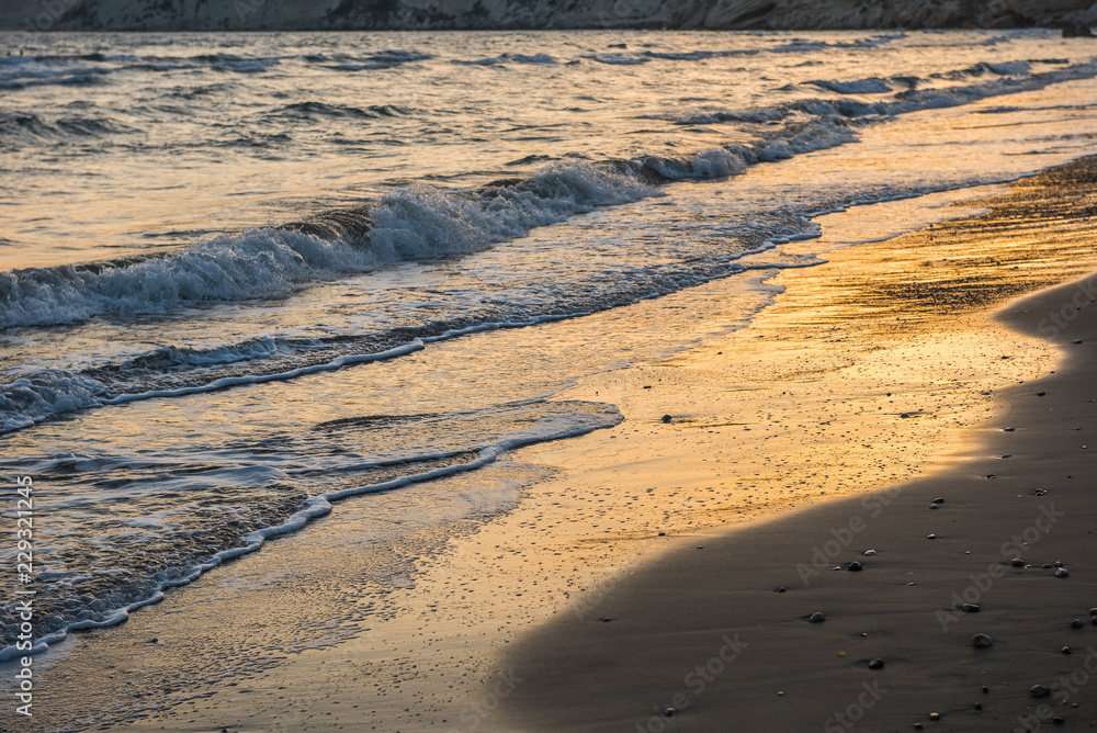 Waves approaching sandy beach during sunset Waves approaching sandy beach during sunset