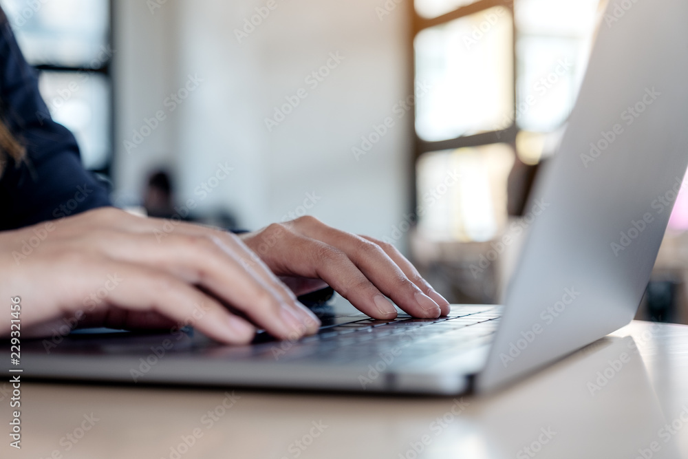Closeup image of hands using and typing on laptop keyboard on table Closeup image of hands using and typing on laptop keyboard on table