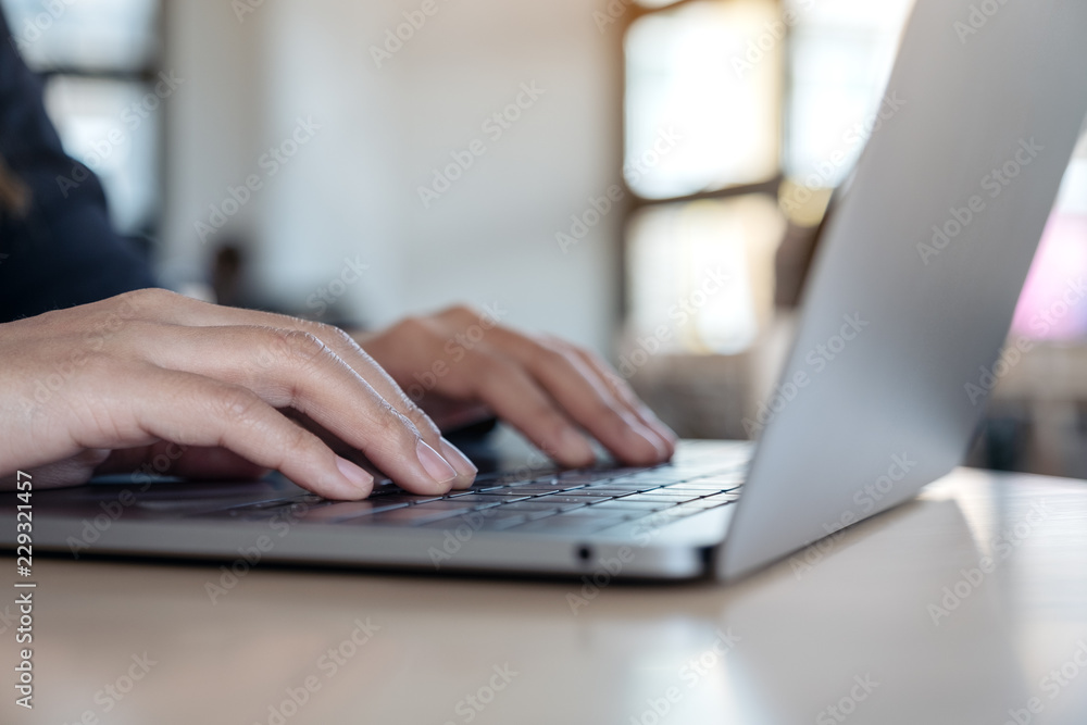 Closeup image of hands using and typing on laptop keyboard on table Closeup image of hands using and typing on laptop keyboard on table