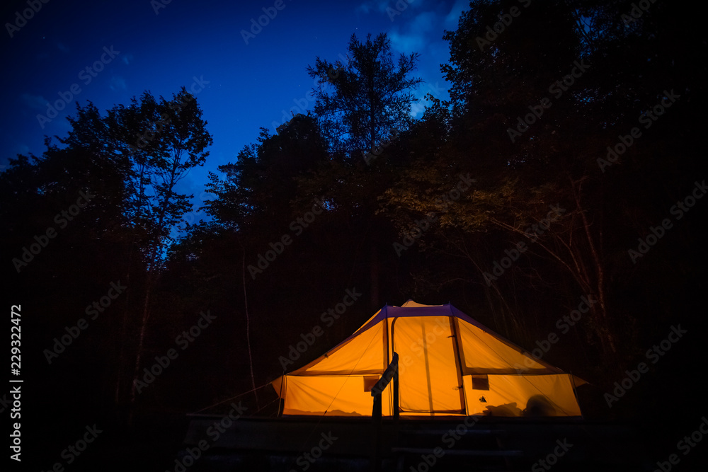 Illuminated family tent at night in Adrenaline Check eco camp in Slovenia.