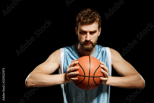 Muscular player squeezing a basketball