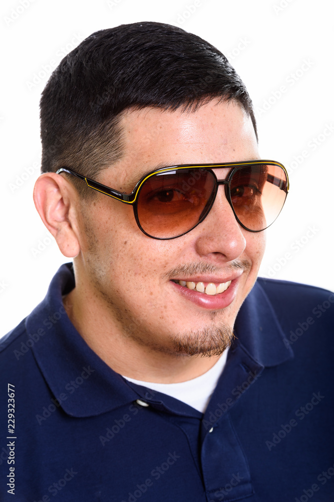 Face of young happy Hispanic man smiling while wearing sunglasse