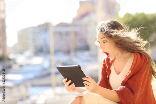 Shocked woman watching online content in a tablet
