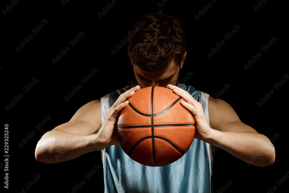 Muscular basketball player on black