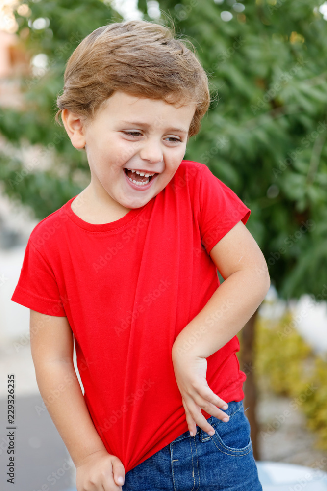 Happy child with red t-shirt in the garden