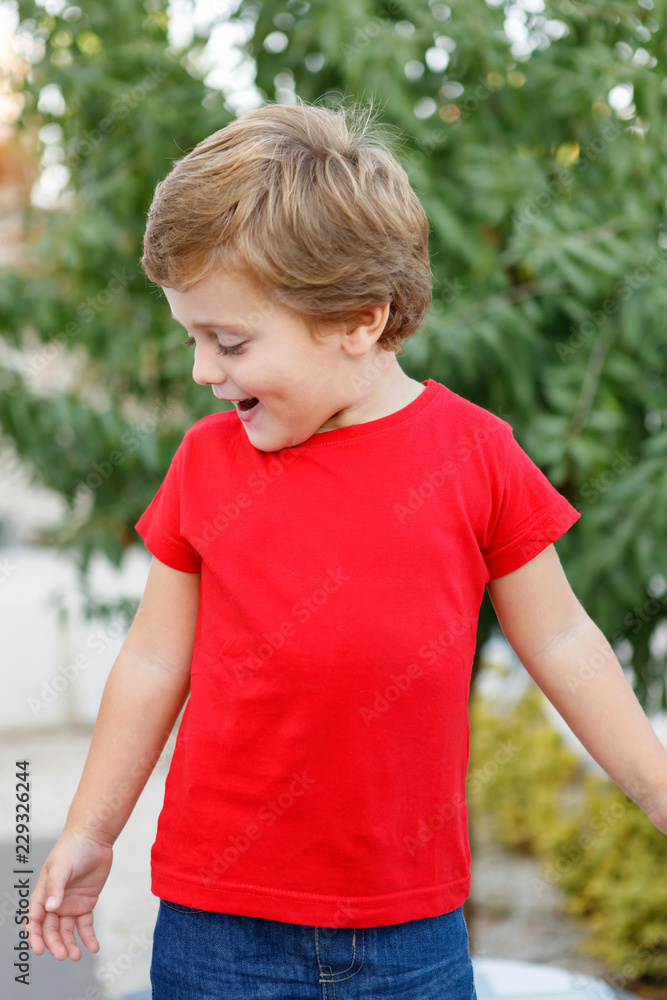 Happy child with red t-shirt in the garden