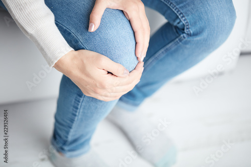 Canvas Print Physical injury of leg / knee / joint - woman holding painful part body
