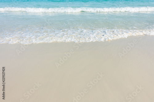 Soft blue ocean wave on sandy beach