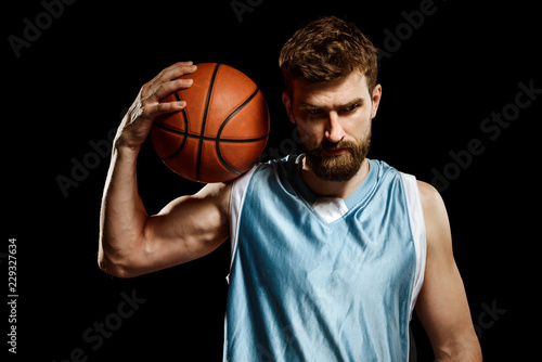 Muscular basketball player on black