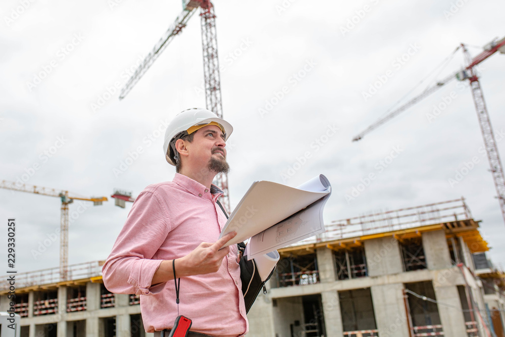Portrait of architect at work with helmet in a construction site,reads the plan. Portrait of architect at work with helmet in a construction site,reads the plan.