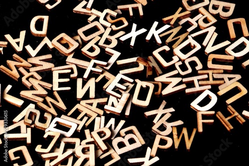 a heap of wooden letters are lying in the dark studio