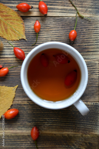 Autumn composition with rose hips nuts leaves a Cup of tea. A Cup of tea with rose hips. Autumn hot drink