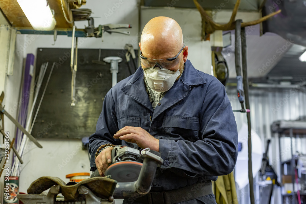 Heavy industry worker cutting steel with angle grinder at car service Heavy industry worker cutting steel with angle grinder at car service